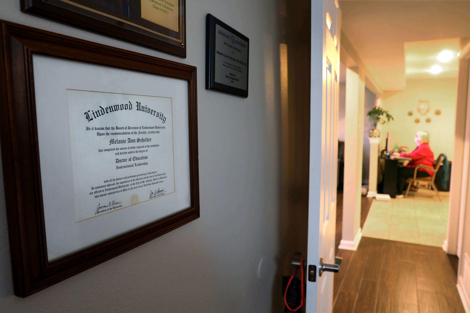 Lonni Schicker's doctorate of education hangs in her bedroom on Wednesday, Feb. 21, 2017. At one time a professor, memory issues forced her to quit and she now works to compile lists of churches.