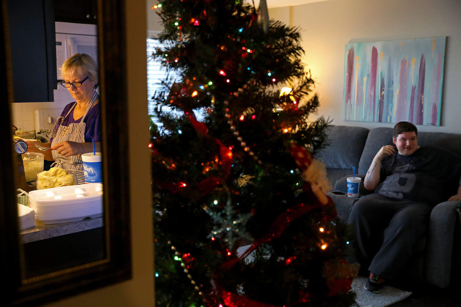 Lonni Schicker prepares a big holiday dinner on Sunday, Dec. 17, 2017, as her son Dan sits nearby in their Fenton living room. Cooking the meal is an outlet for Lonni, who encouraged Dan and his friends to gather at their house when Dan was growing up. She can no longer cook when she is alone. Dan has to be at home or on his way before she can start working the stove.