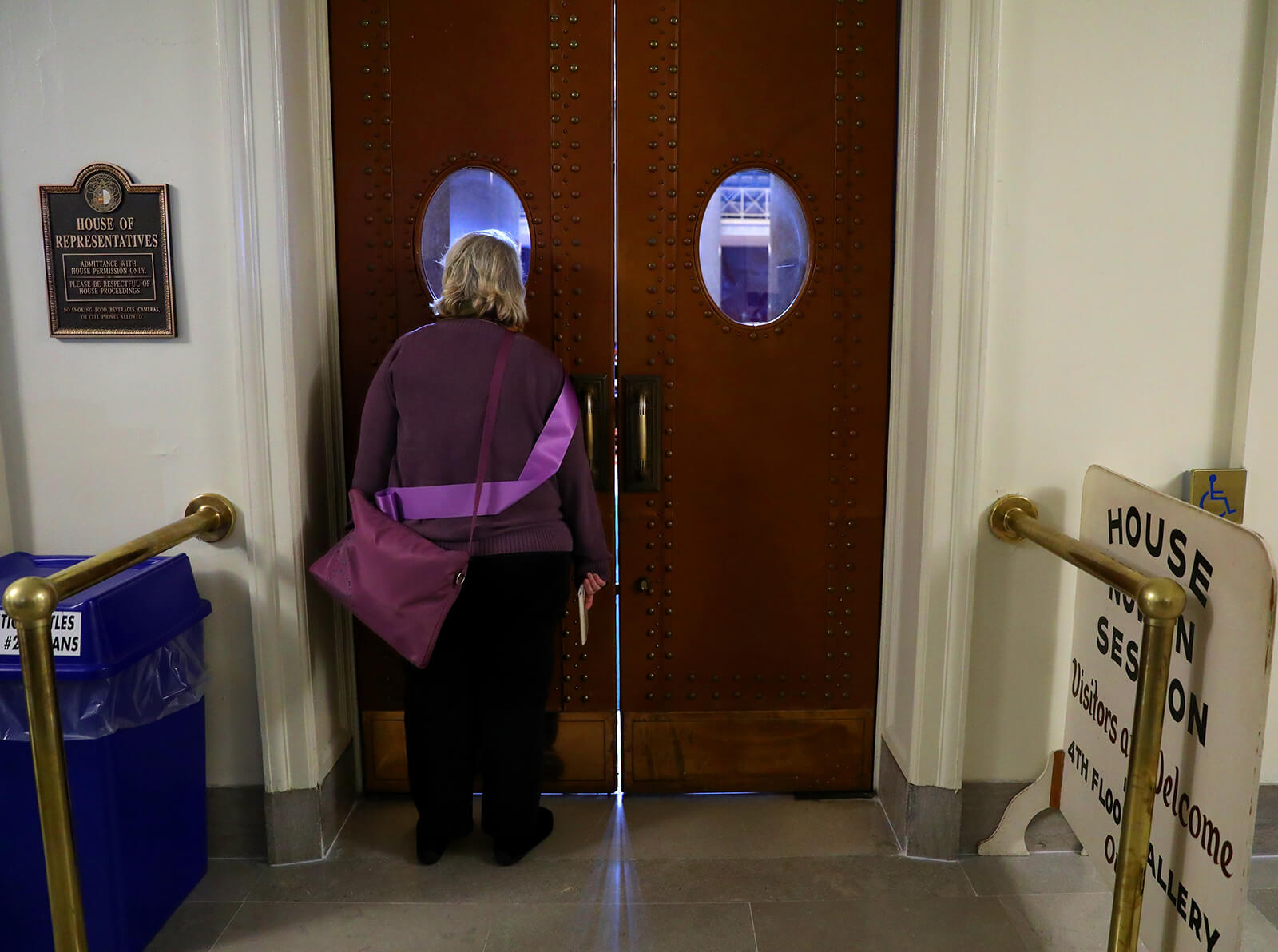 Lonni Schicker peeks at the floor of the House of Representatives at the Missouri Capitol on Wednesday, March 7, 2018. She and other Alzheimer's Association advocates went to Jefferson City to lobby lawmakers and rally for their cause.