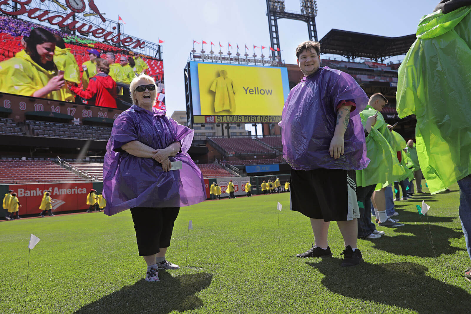 Lonni Schicker and her son Dan Schicker share a laugh as they stand in Busch Stadium with hundreds of participants waiting to help the Alzheimer's Association and Edward Jones set a Guinness World Record for the largest human image of a brain on Saturday, April 28, 2018. Participants wore different colored ponchos for different parts of the brain. The record was set with 1,202 participants.