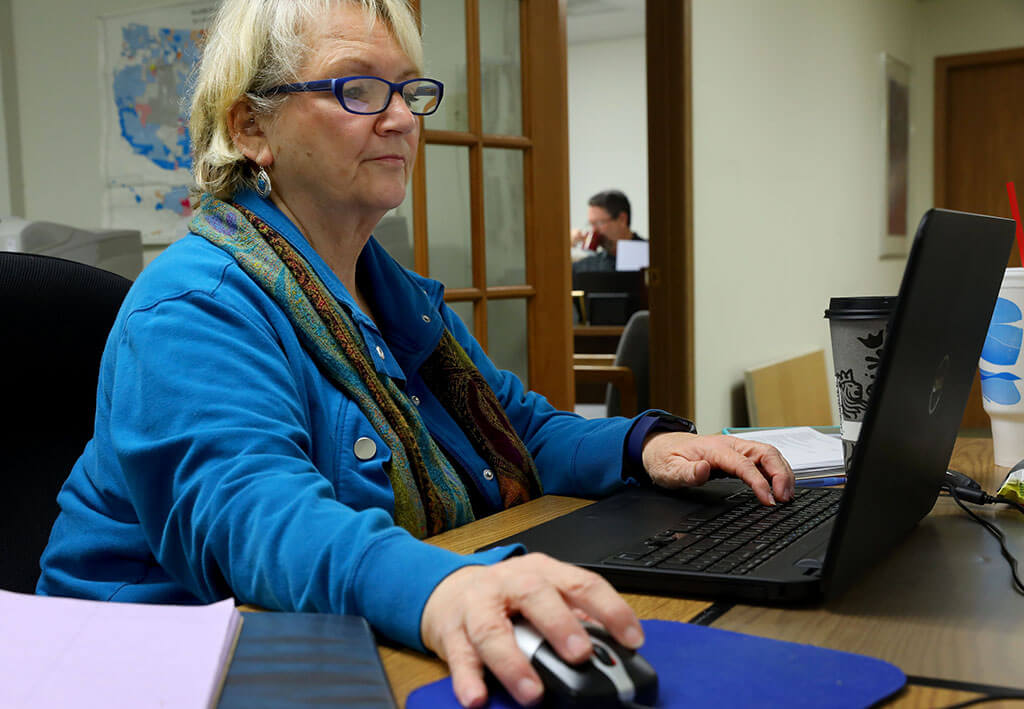 Lonni Schicker works at her part-time job researching churches for Guide Book Publishing in Ballwin. She has had to quit driving and now works from home.