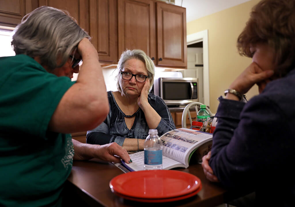 Lonni Schicker (center) listens as Janis McGillick (left) goes over assisted living housing costs in the Seniors' Resource guide on Friday, March 23, 2018, at Dolan Memory Care Home in west St. Louis County. McGillick is the director of community engagement for the company that runs Dolan. Lonni, accompanied by her friend Susan Miller (right), met for a tour.