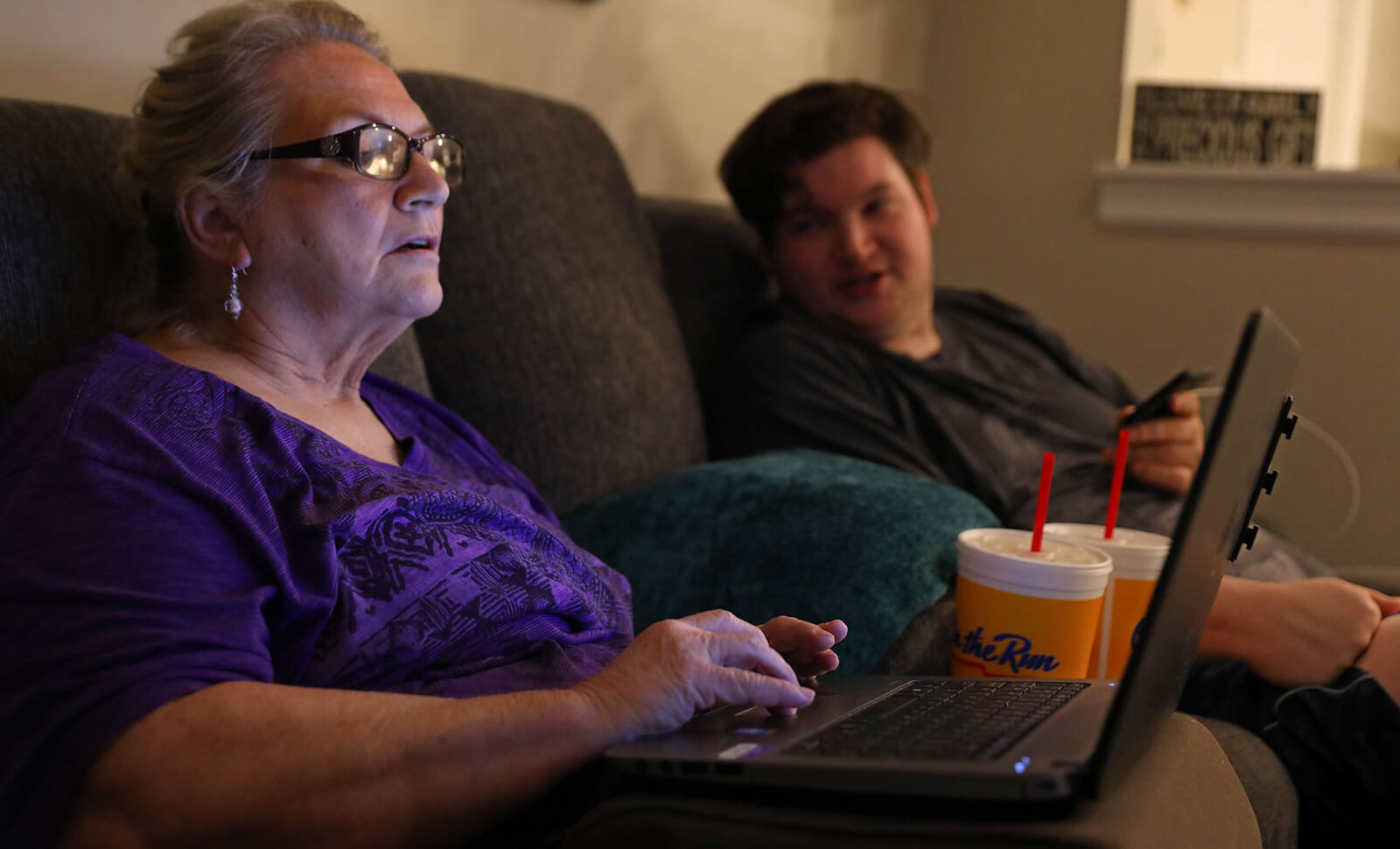 Lonni and Dan Schicker work out a computer issue in the apartment they share in Fenton on Monday, July 30, 2018. Lonni, who has dementia, says she worries that Dan is caring for her out of guilt.